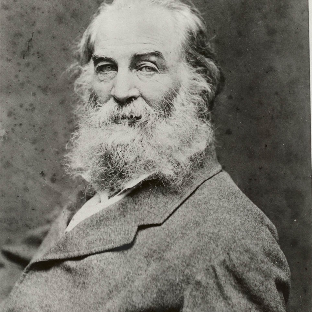 A black and white photo of Walt Whitman facing the left but looking into the camera
