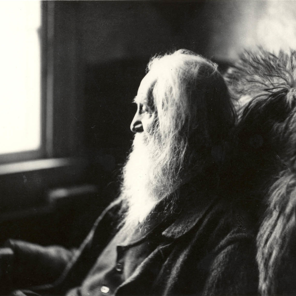 A photo of Walt Whitman looking out a window.
